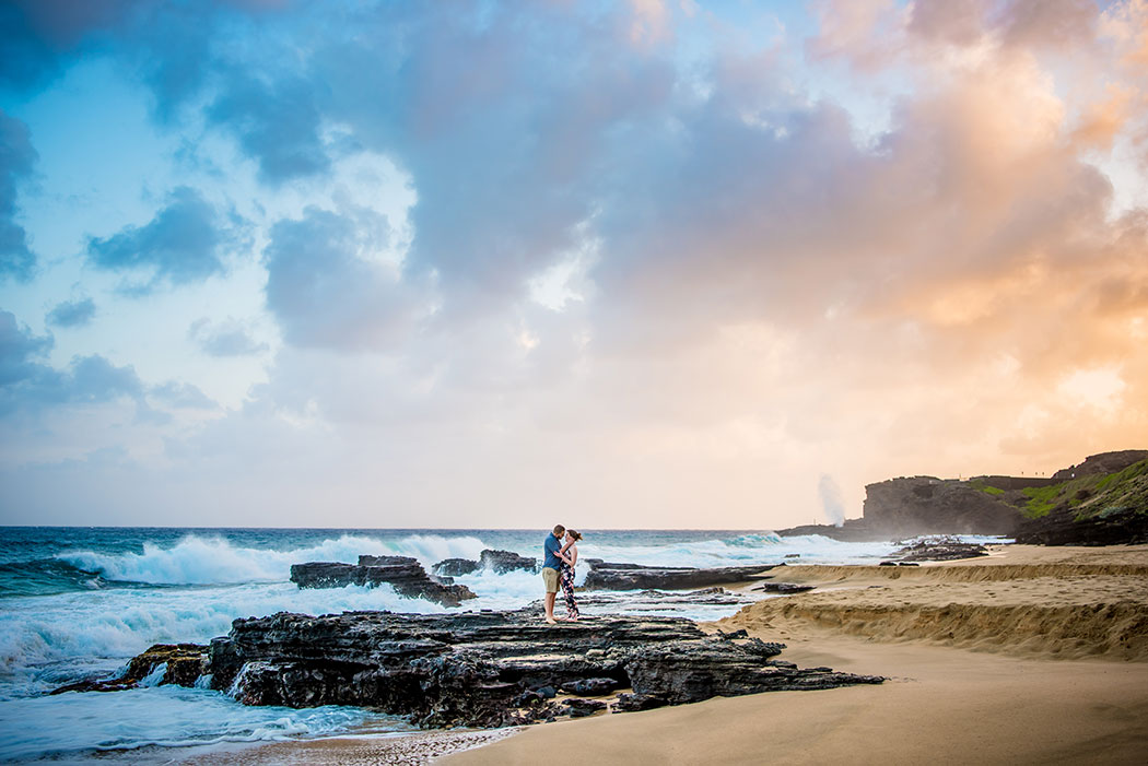 Portrait of a couple on a rocky beach on the Eastern shore of Oahu with a dramatic sky.